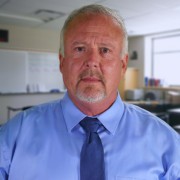 Man with receding gray hair and gray mustache and goatee